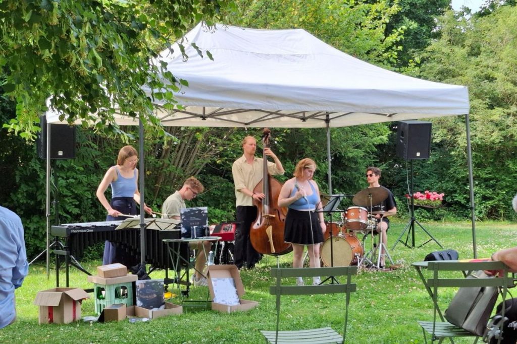Das Bild zeigt die Folkwang-Studierenden-Band "KNUD" beim Auftritt zum Tag der älteren Generationen 2025 im Grugapark Essen (Photocredit: Monika Riech, Senioren-Assistenz).